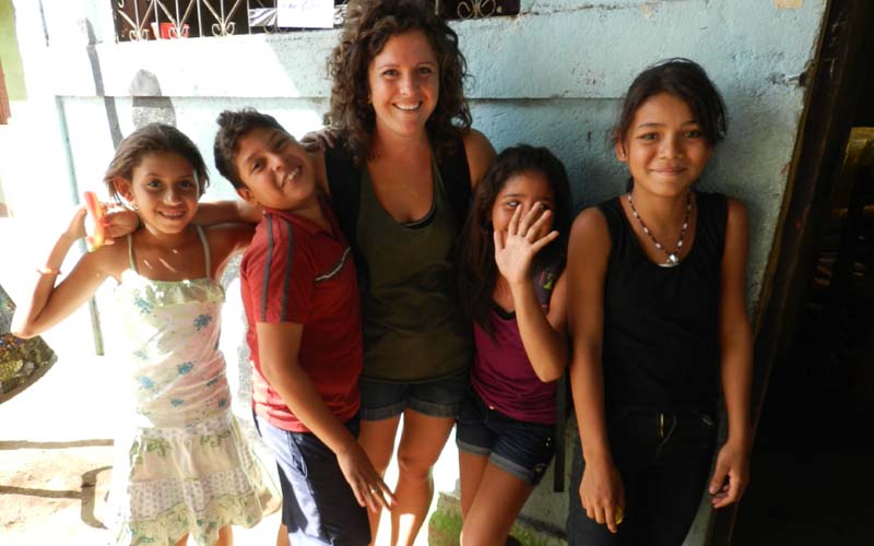 a Volunteer teaching English abroad and her students