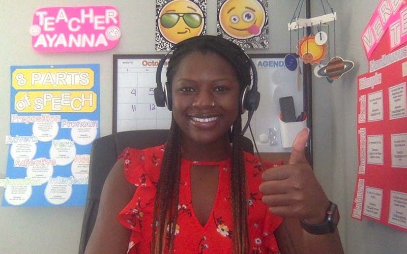 ITA grad Ayanna gives a smile and a thumbs up to her online English students